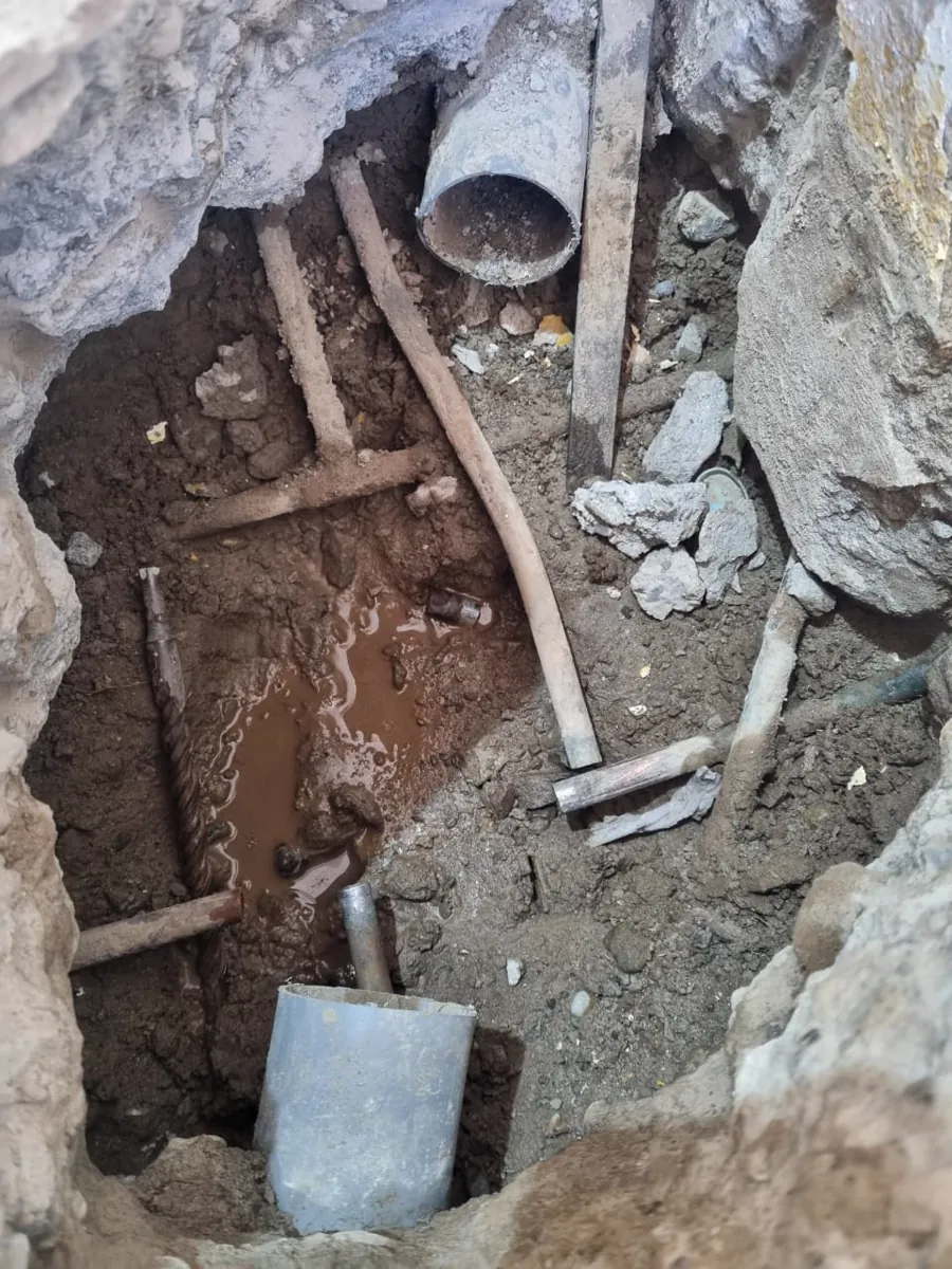 Excavación con agua acumulada alrededor de las cañerías