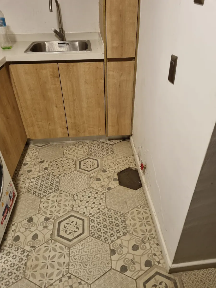 Cocina ordenada con el piso tapado tras la reparación